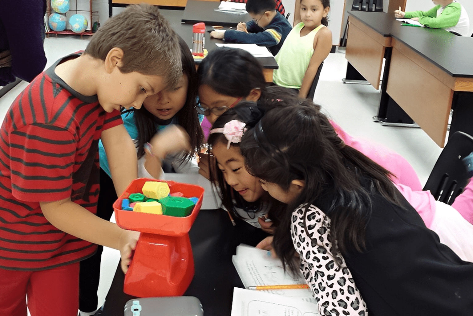 Children using a scale in classroom activity.